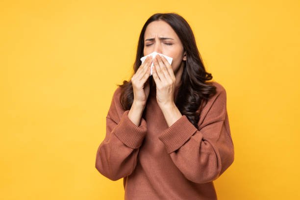 Woman sneezing from allergies